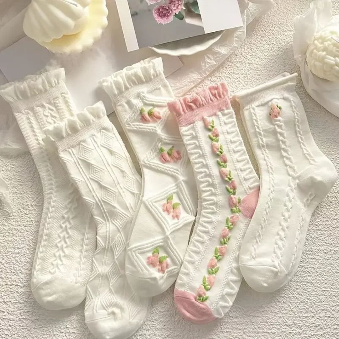 Weiße und rosa gestrickte Socken mit Blumenmuster, Baumwolle, Damenmode, gemütlich.