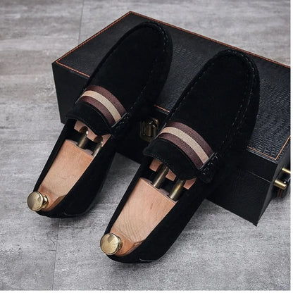 Schwarze Wildleder-Loafer mit Holzschuhspanner auf grauem Boden, elegante Herrenschuhe.