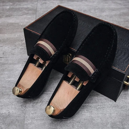 Schwarze Wildleder-Loafer mit Holzschuhspanner auf grauem Boden, elegante Herrenschuhe.