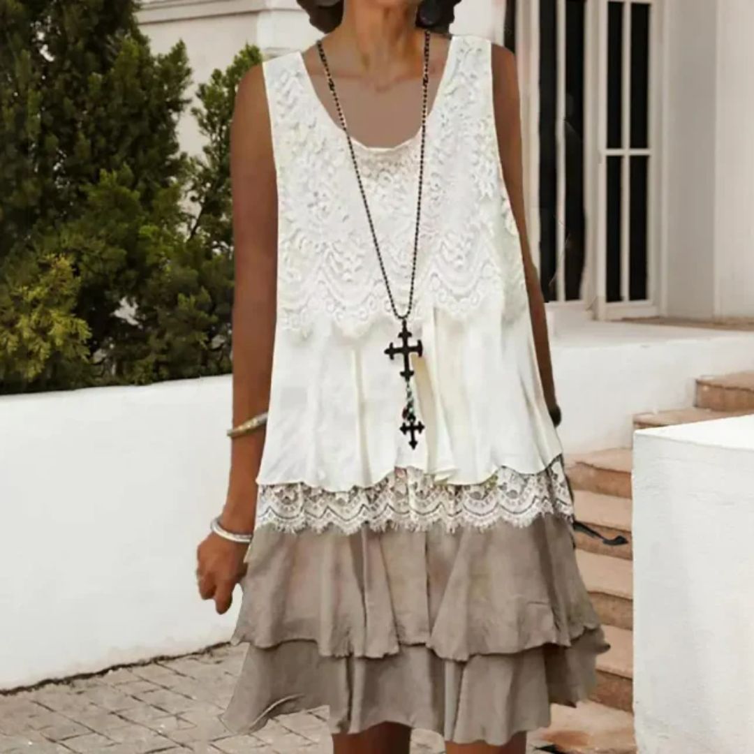 Frau in weißem Spitzenkleid mit Kreuzkette, Sommermode, ärmellos, lässig, elegant.