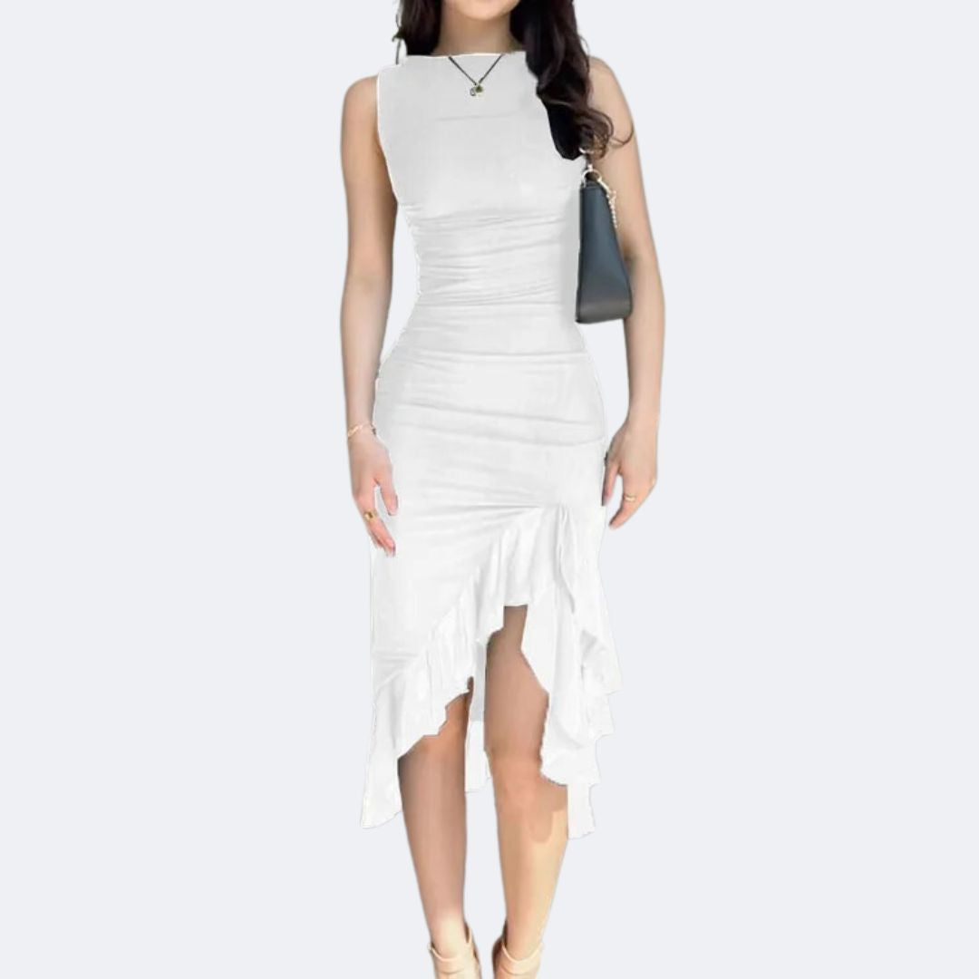 Frau in weißem ärmellosen Kleid mit asymmetrischem Saum und schwarzer Handtasche.