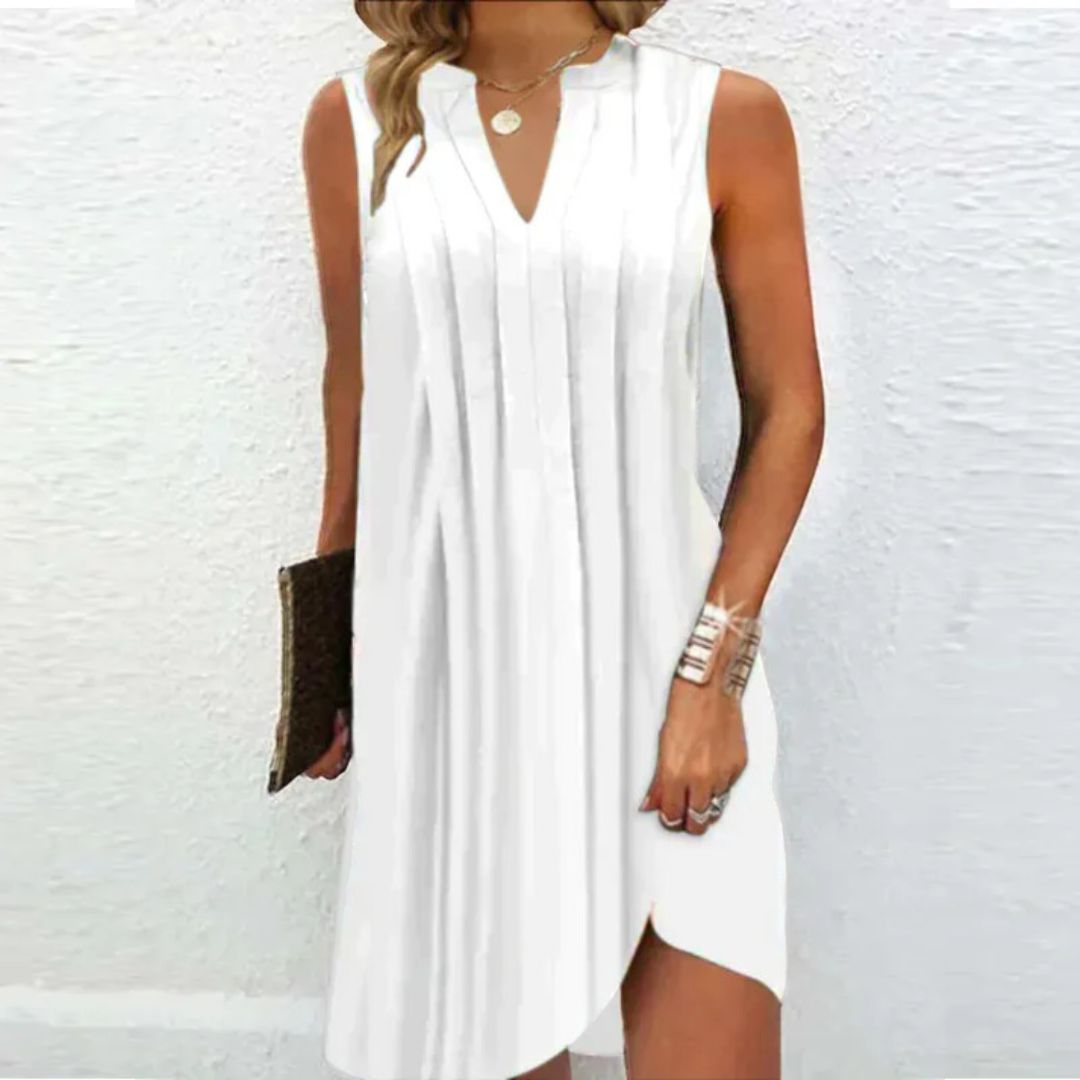 Frau in weißem ärmellosen Sommerkleid mit V-Ausschnitt, hält eine braune Clutch.