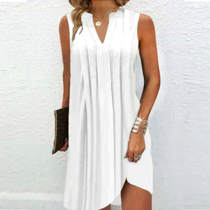 Frau in weißem ärmellosen Sommerkleid mit V-Ausschnitt, hält eine braune Clutch.