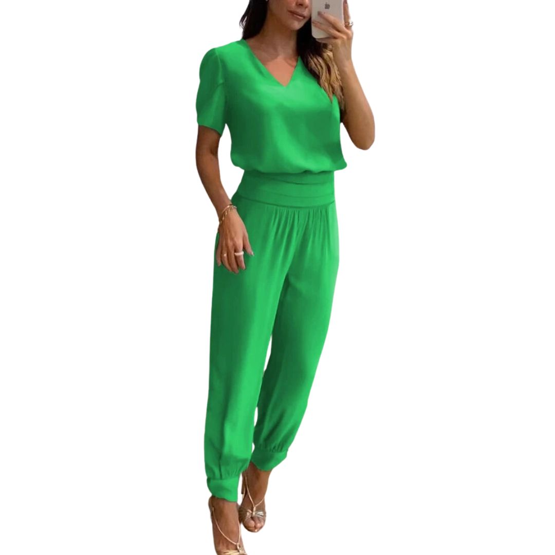 Frau in grünem Jumpsuit, V-Ausschnitt, kurze Ärmel, elegantes Design, modische Damenbekleidung.