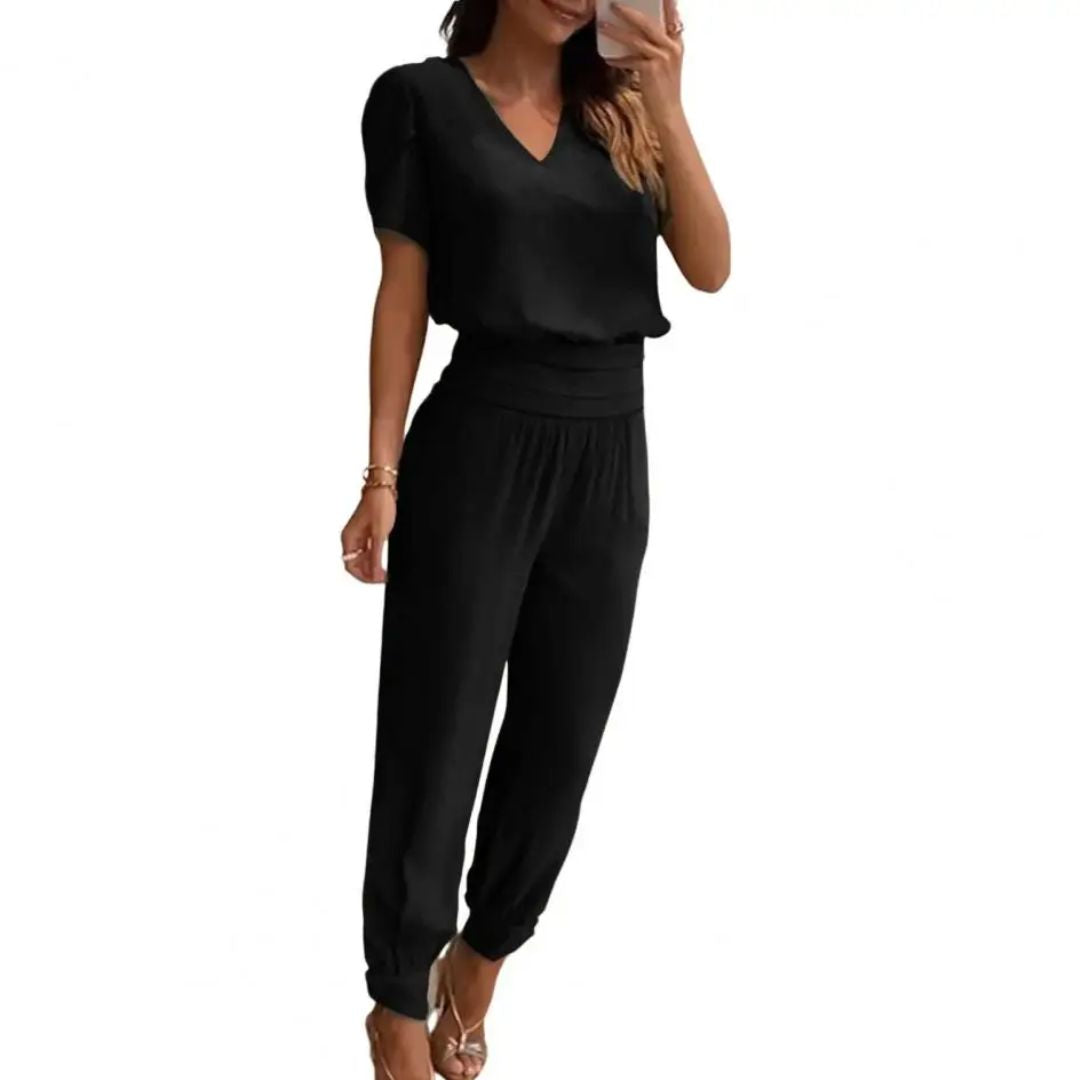 Frau in schwarzem Jumpsuit, V-Ausschnitt, kurze Ärmel, elegantes Design, Modekleidung.