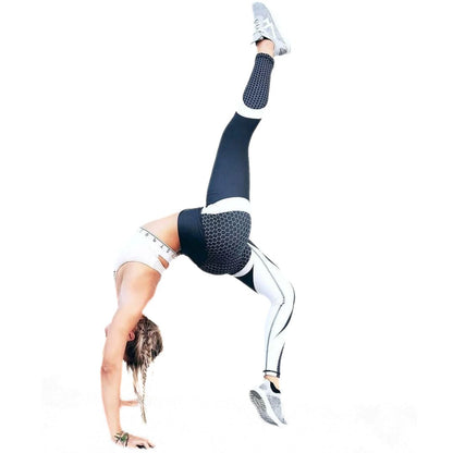 Frau in schwarz-weißer Sportbekleidung macht Yoga-Übung, Handstand, Fitness, Flexibilität.