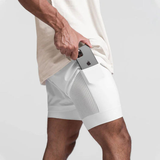 Mann in weißen Sportshorts mit Smartphone in der Tasche, Fitnessbekleidung, Herrenmode.