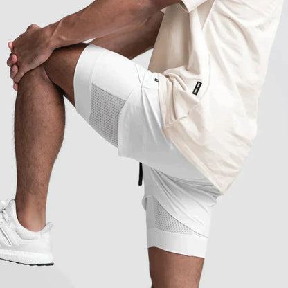 Mann in weißen Sportshorts und Sneakers, knielang, atmungsaktiv, ideal für Fitness und Laufen.