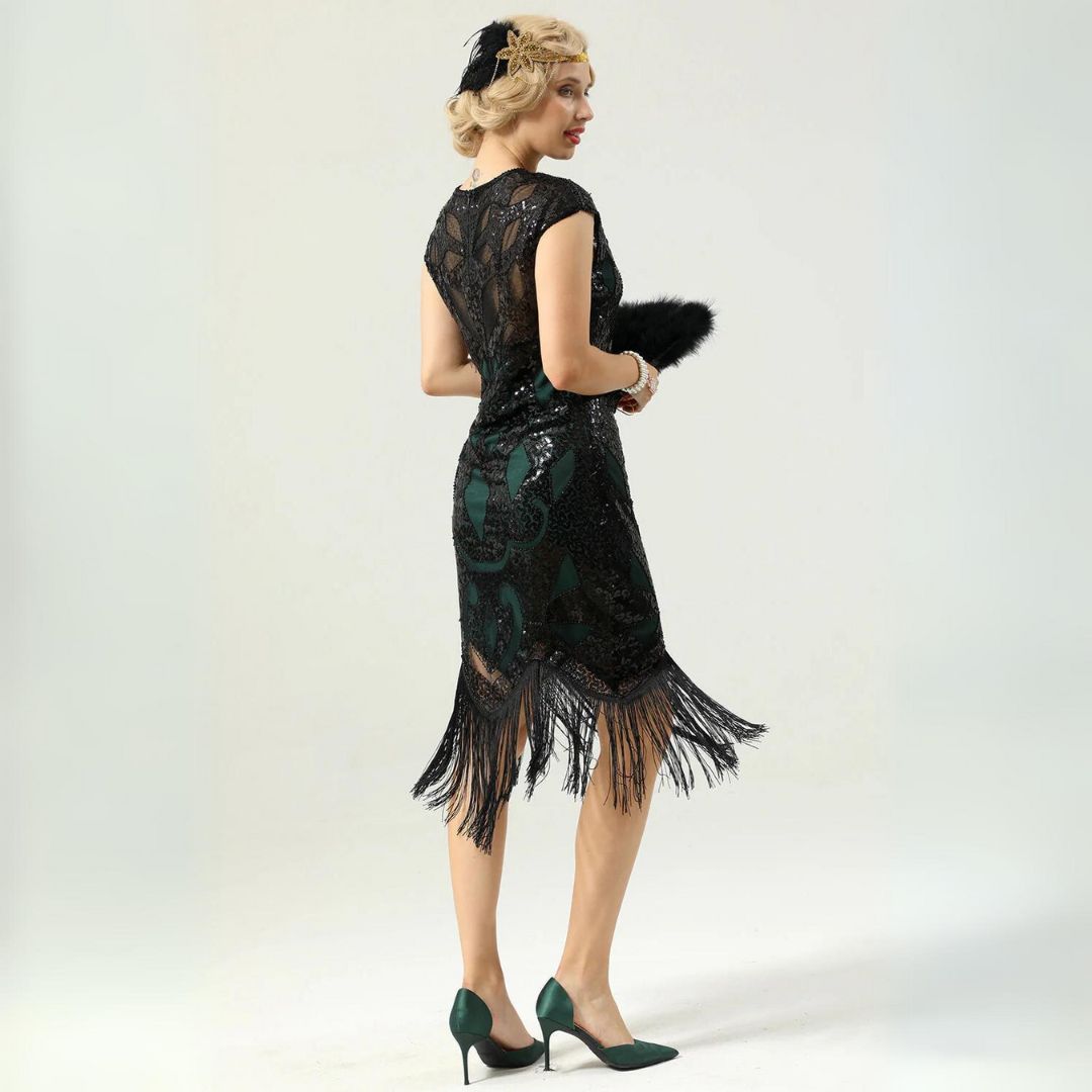 Frau im schwarzen Spitzenkleid mit Fransen, grünen High Heels, 1920er Jahre Stil.