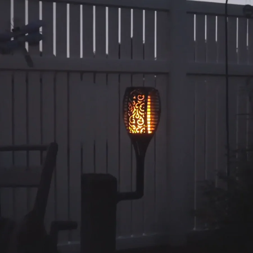 Solarbetriebene Gartenfackel mit Flammen-Effekt, dekorative Beleuchtung, schwarz, im Freien.