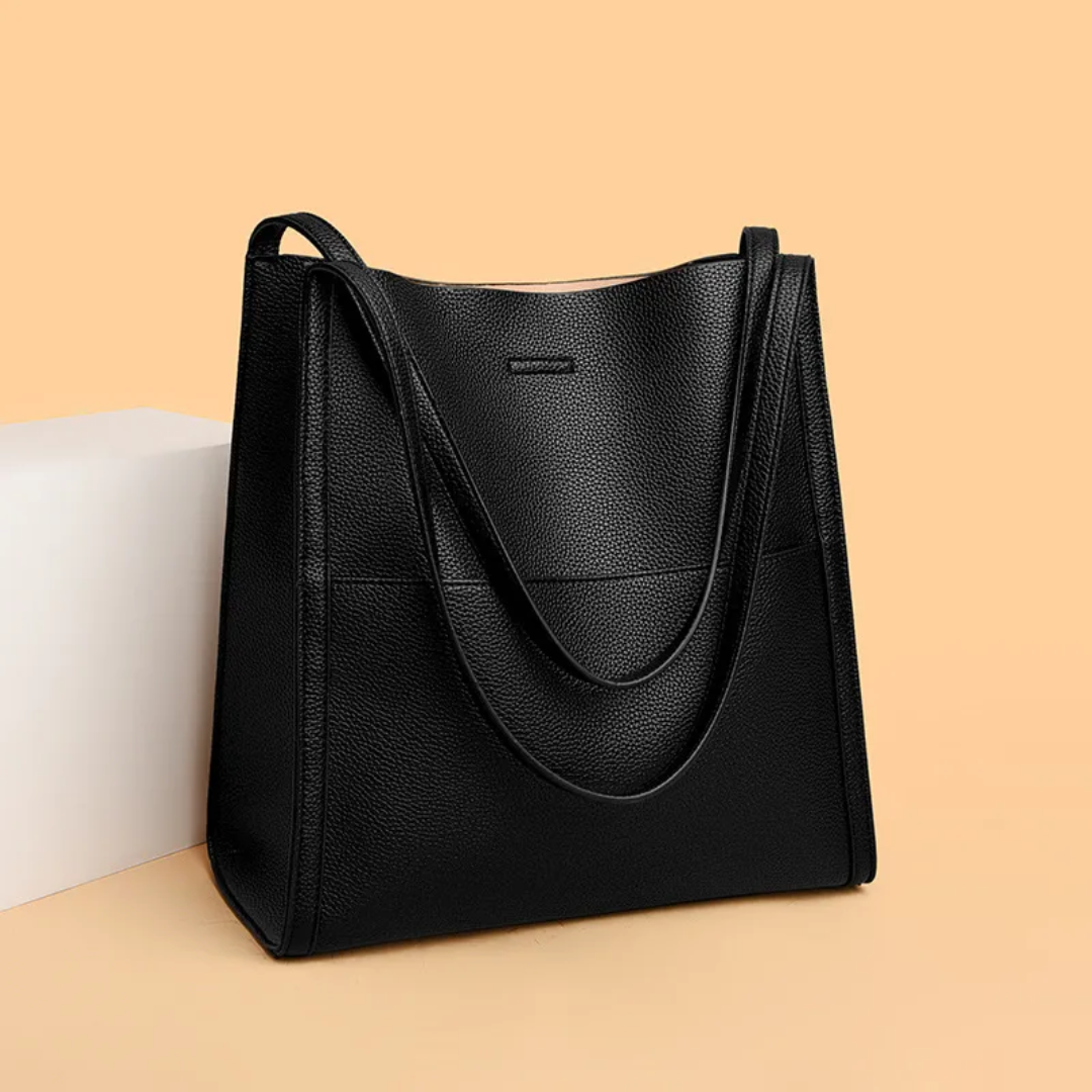 Schwarze Lederhandtasche, elegant, geräumig, Damenmode, Accessoire, auf beigem Hintergrund.