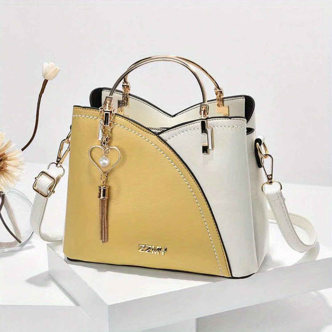 Zweifarbige Damenhandtasche, gelb-weiß, Leder, mit Herzanhänger, elegantes Design.