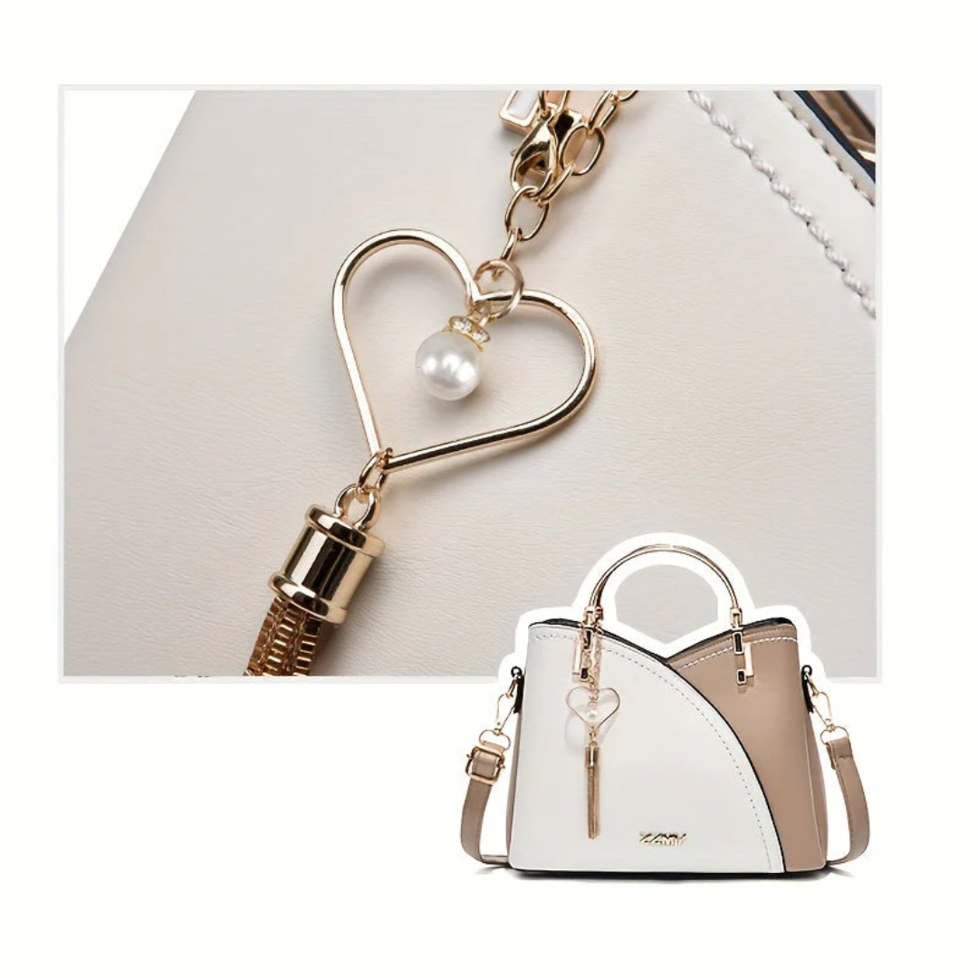 Weiße Damenhandtasche mit Herzanhänger, Leder, elegant, modisch, Schulterriemen.
