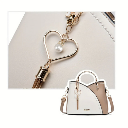 Weiße Damenhandtasche mit Herzanhänger, Leder, elegant, modisch, Schulterriemen.