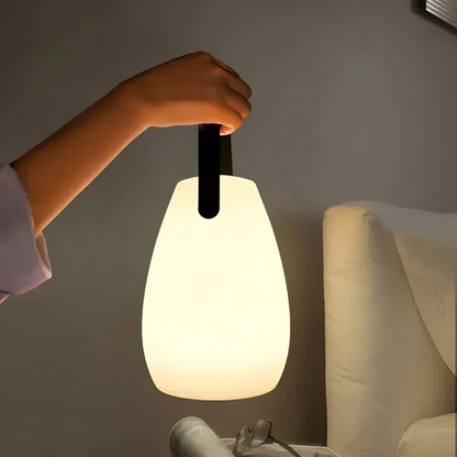 Tragbare LED-Lampe, weiß, mit schwarzem Griff, ideal für Schlafzimmerbeleuchtung.