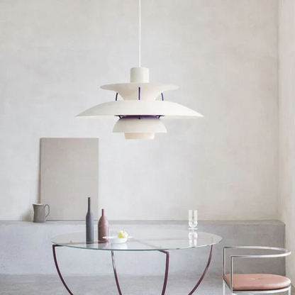 Moderne weiße Pendelleuchte über rundem Glastisch in minimalistischem Wohnzimmer.