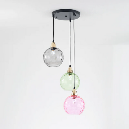 Moderne dreifarbige Pendelleuchte mit Glaslampenschirmen in Schwarz, Grün und Rosa.