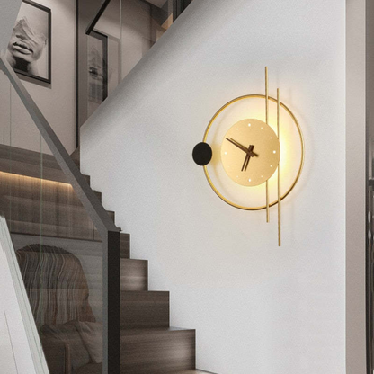 Moderne Wanduhr aus Metall, goldfarben, mit LED-Beleuchtung, an Treppenhauswand montiert.