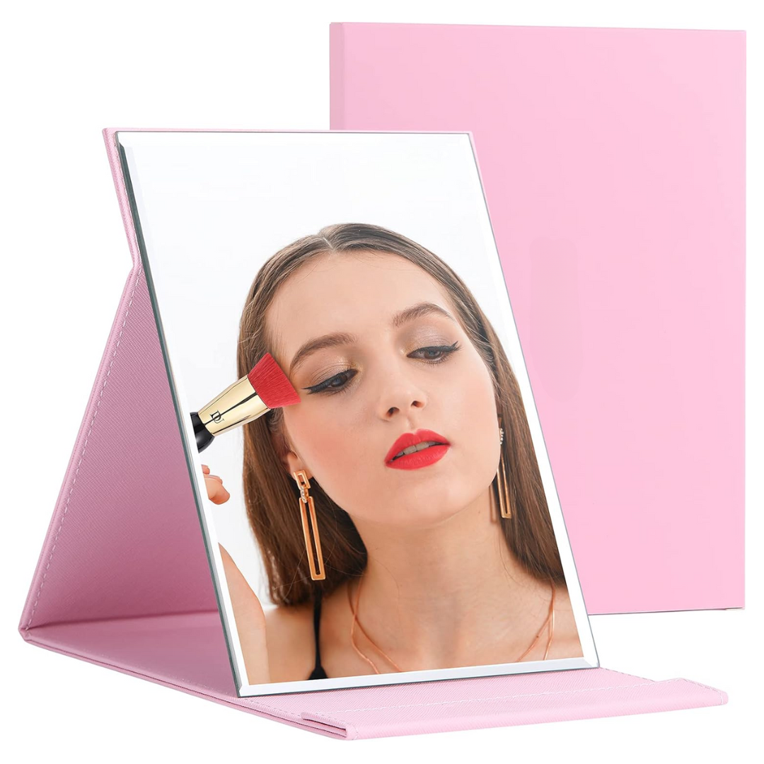 Rosa klappbarer Schminkspiegel mit Frau beim Schminken, ideal für Make-up und Reisen.