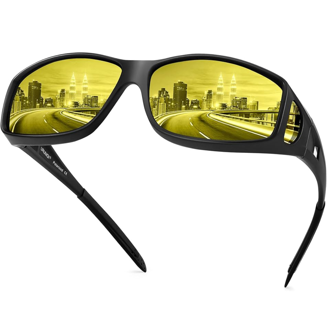 Schwarze Nachtsichtbrille mit gelben Gläsern für Autofahren, Stadtlandschaft im Hintergrund.