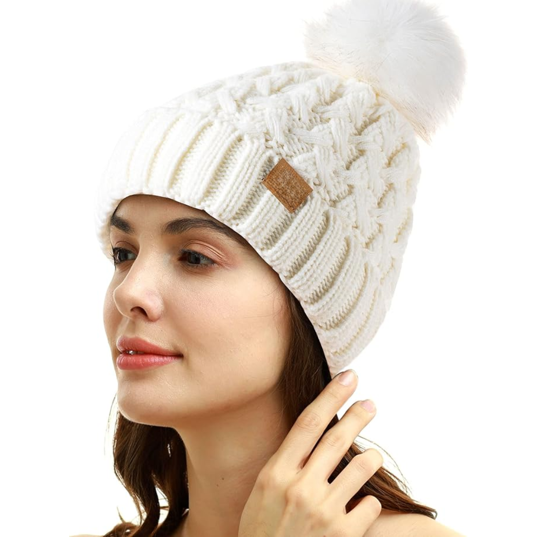 Frau mit weißer Strickmütze, Bommel, Wintermode, Damenaccessoire, warm, stilvoll.