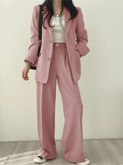 Frau in rosa Anzug mit weißem Top und Sneakers, modisch, elegant, Business-Look.