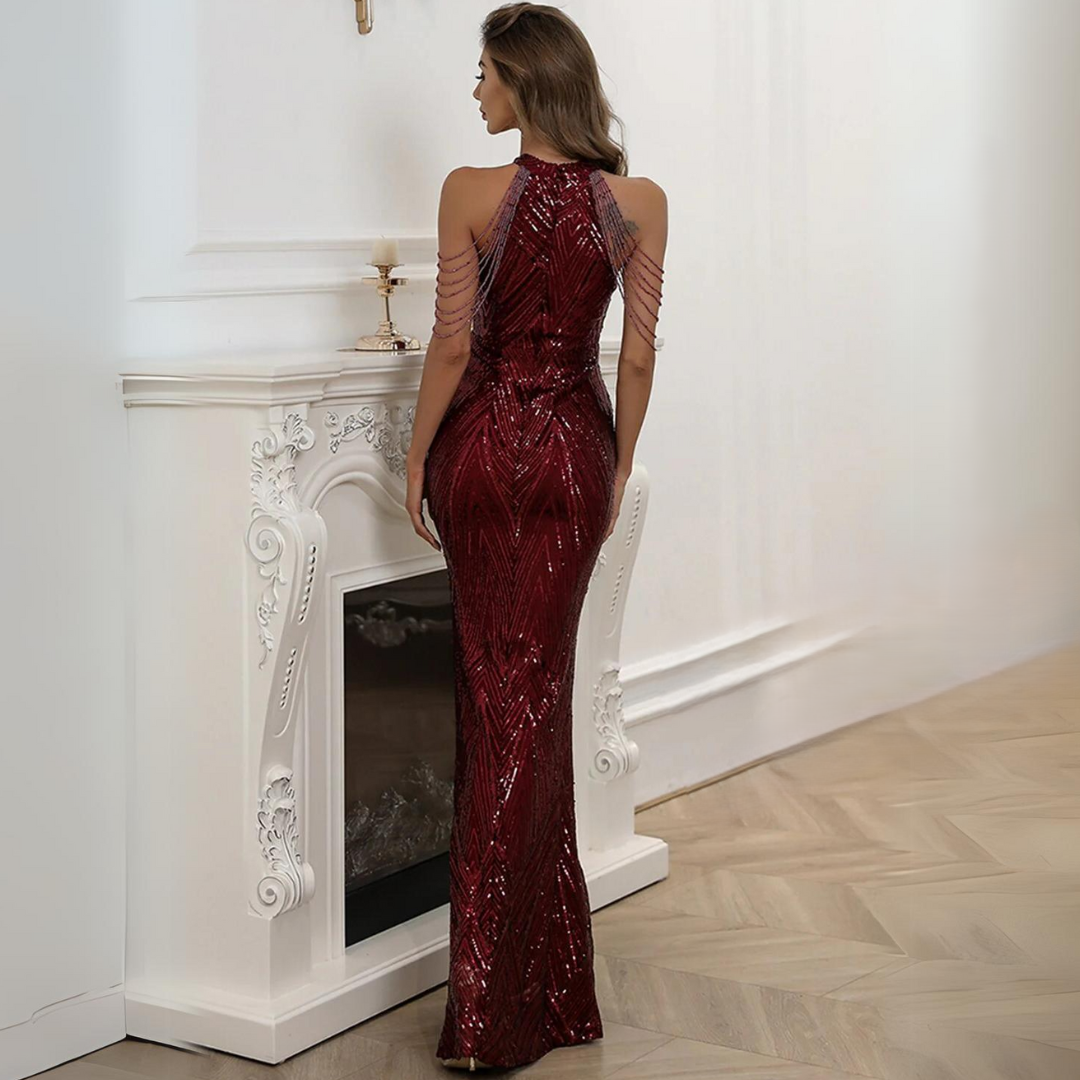 Frau in rotem Paillettenkleid vor weißem Kamin, elegantes Abendmode-Outfit.
