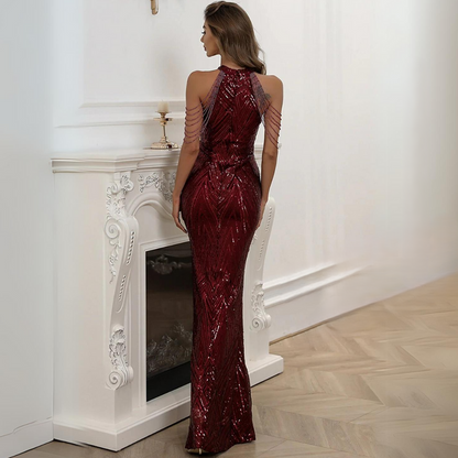 Frau in rotem Paillettenkleid vor weißem Kamin, elegantes Abendmode-Outfit.