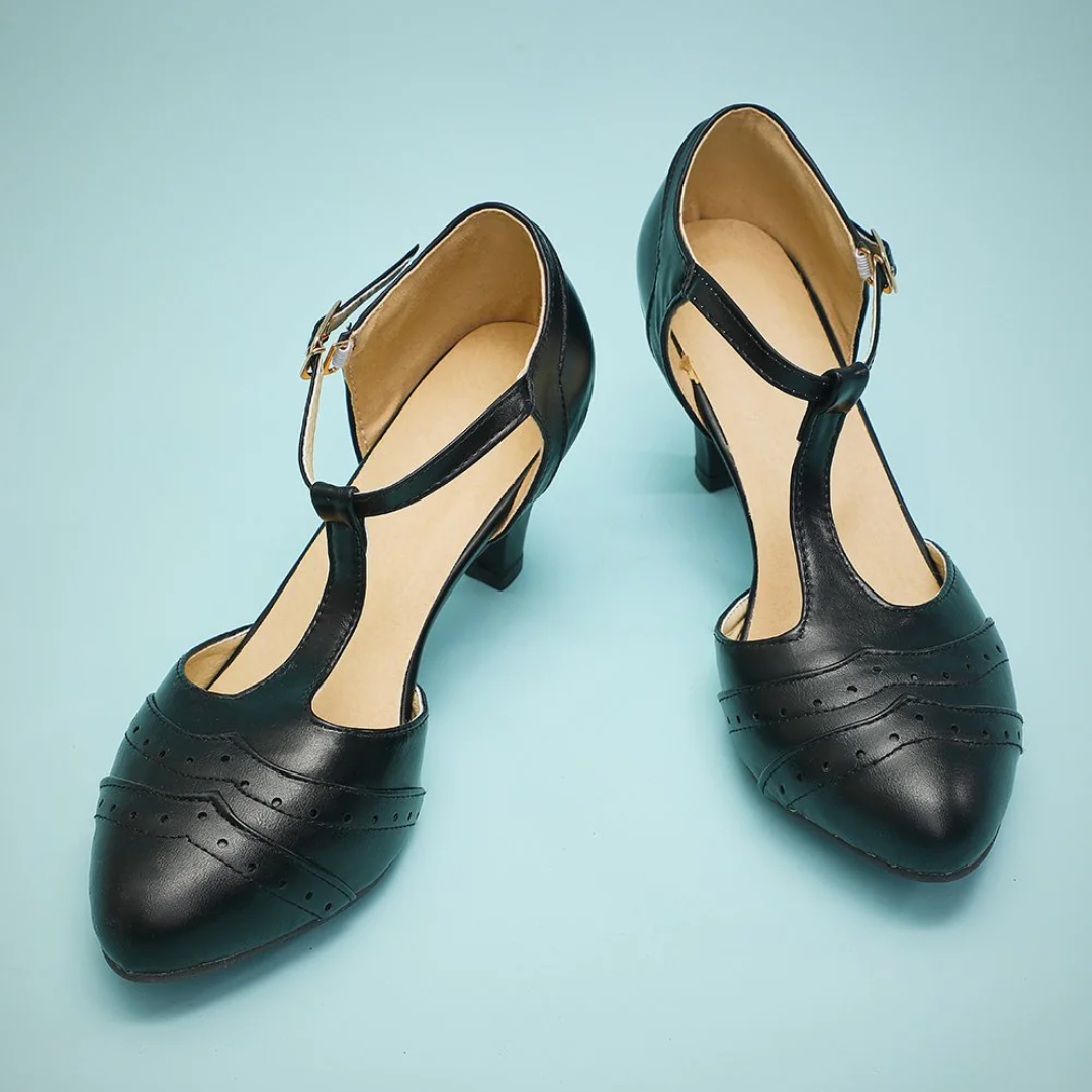 Schwarze Damen-T-Steg-Pumps aus Leder mit Schnalle auf blauem Hintergrund.