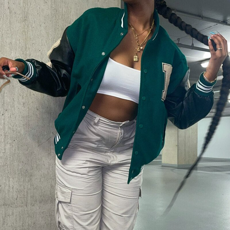 Frau in grüner College-Baseballjacke, weißem Top und Cargo-Hose, Streetwear-Mode.