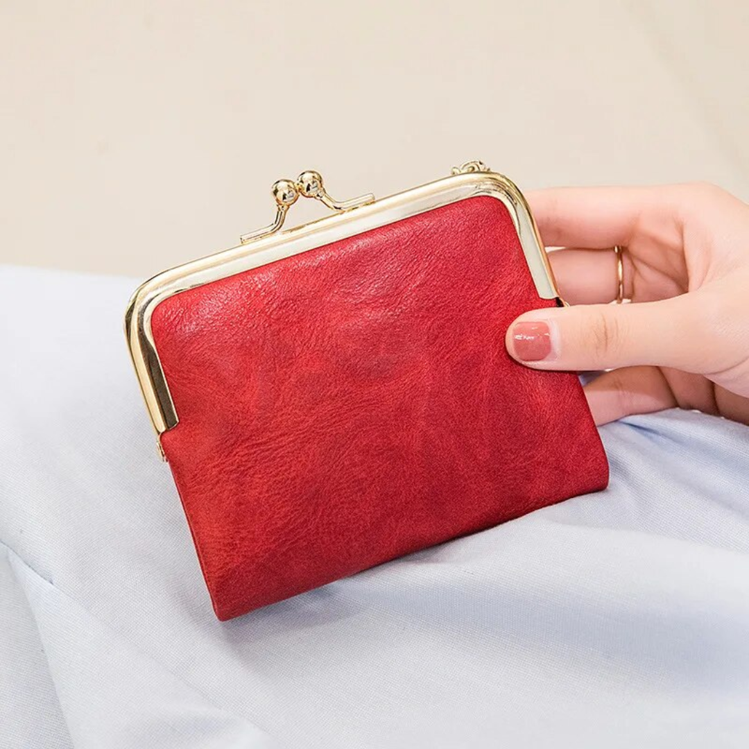 Rote Vintage-Kisslock-Geldbörse aus Leder, handgehalten, elegantes Design.