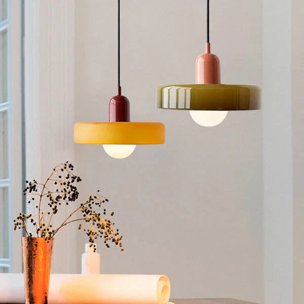 Zwei moderne Hängelampen, gelb und grün, aus Keramik über einem Tisch, skandinavisches Design.