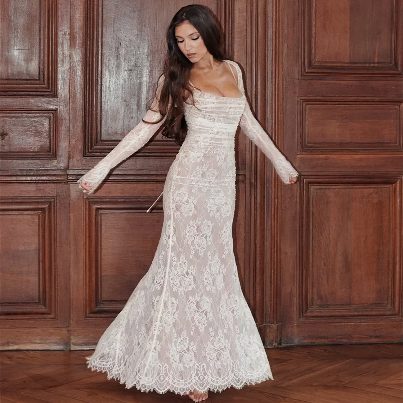 Frau in weißem Spitzenkleid, langärmelig, figurbetont, vor Holztüren, elegante Abendmode.
