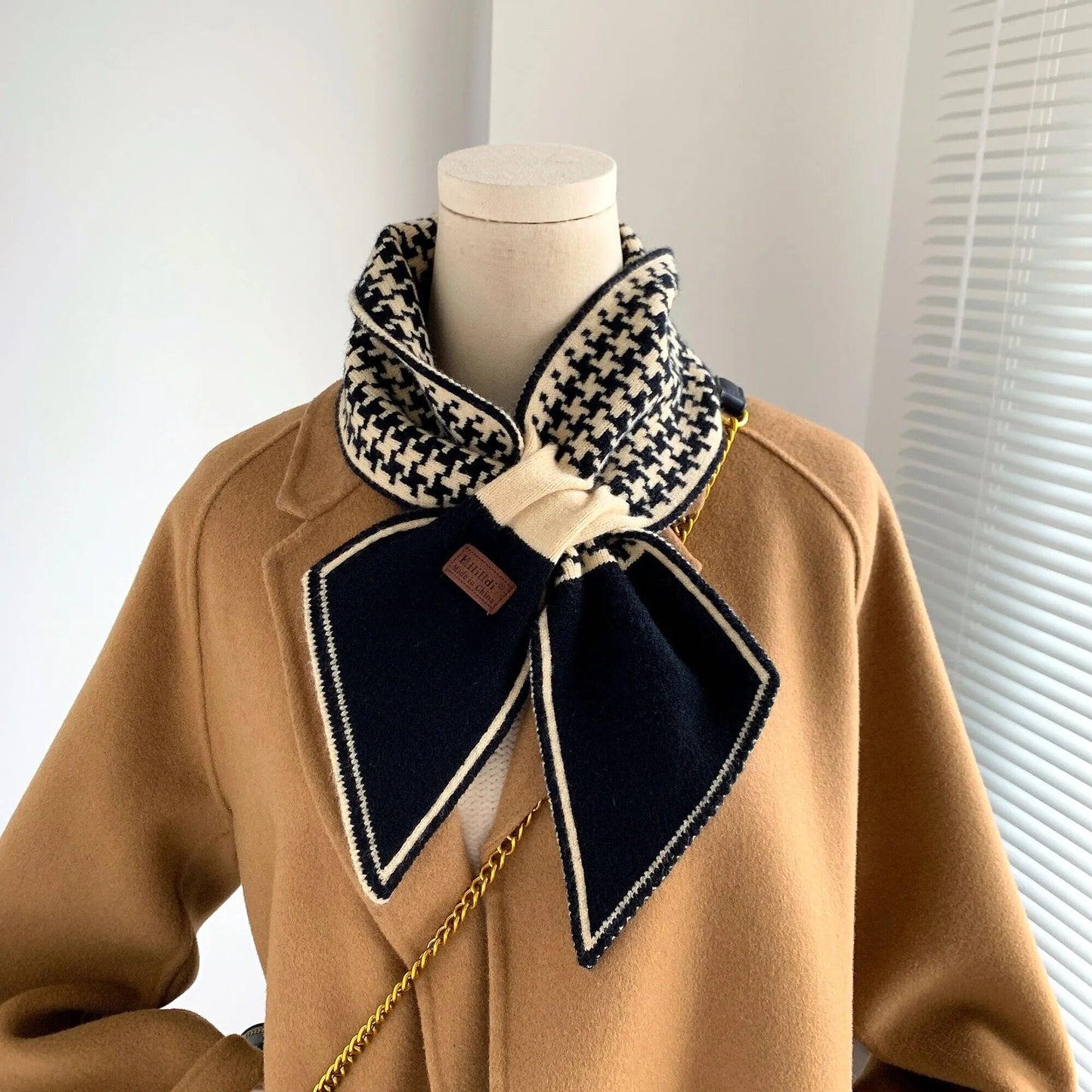 Brauner Mantel mit schwarz-weißem Hahnentritt-Schal, elegantes Winteroutfit, Damenmode.