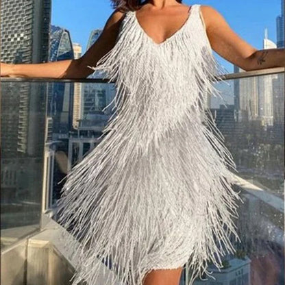 Frau in weißem Fransen-Kleid auf Balkon mit Stadtblick, elegantes Abendkleid, Sommermode.
