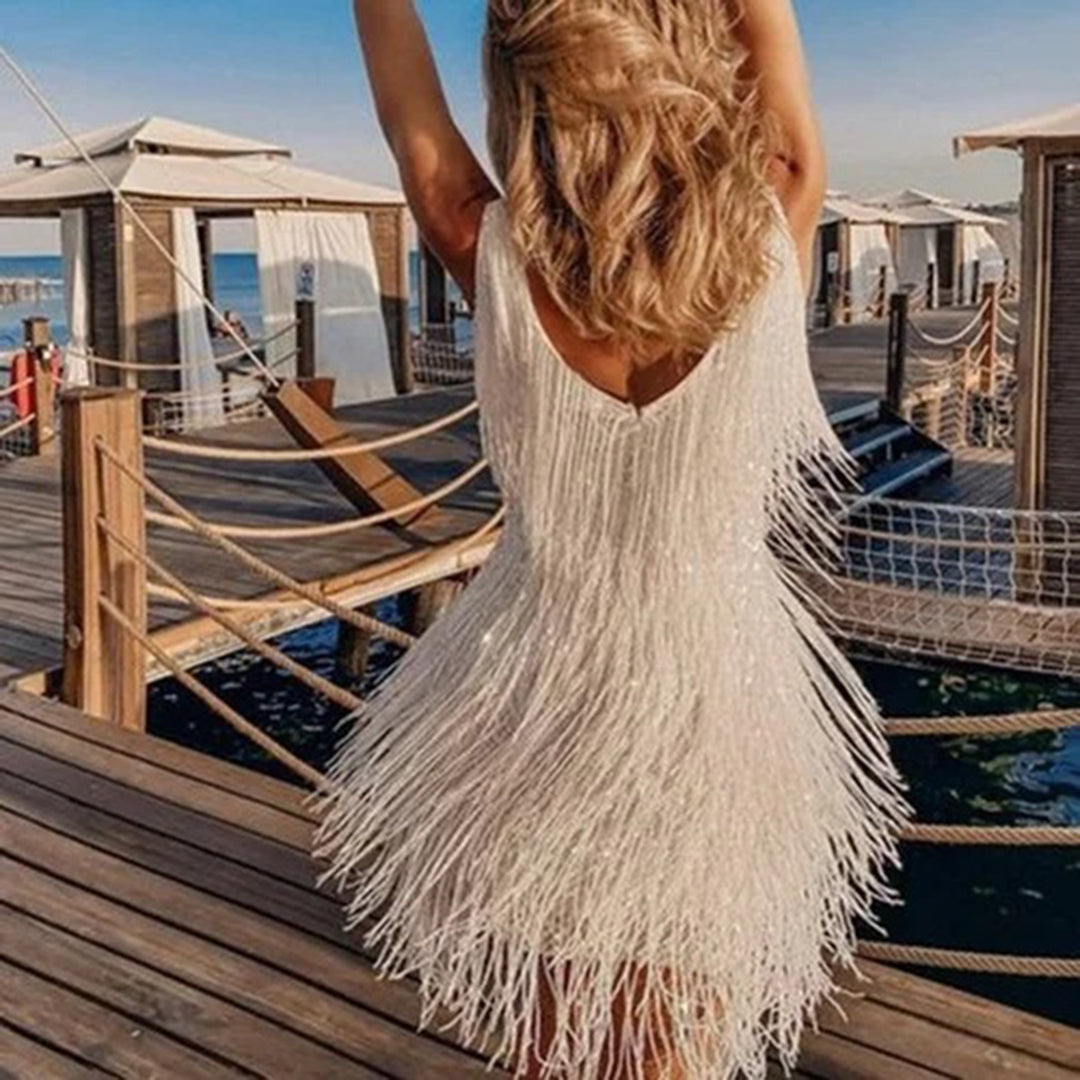 Frau im weißen Fransen-Kleid am Strandsteg, Sommermode, elegantes Abendkleid, Urlaubsoutfit.