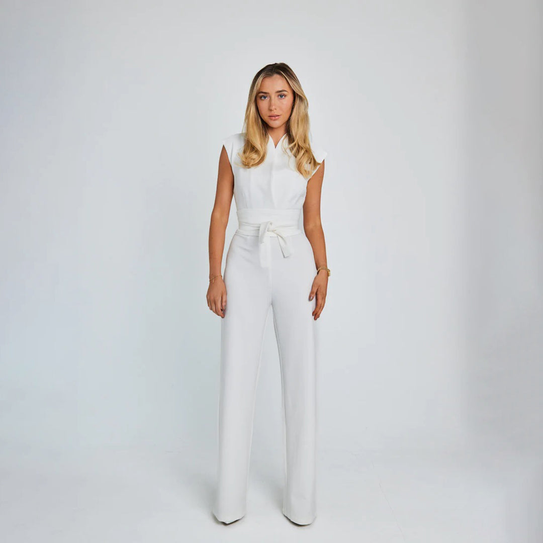 Frau in weißem ärmellosen Jumpsuit, elegantes Design, Modefotografie, Studioaufnahme.