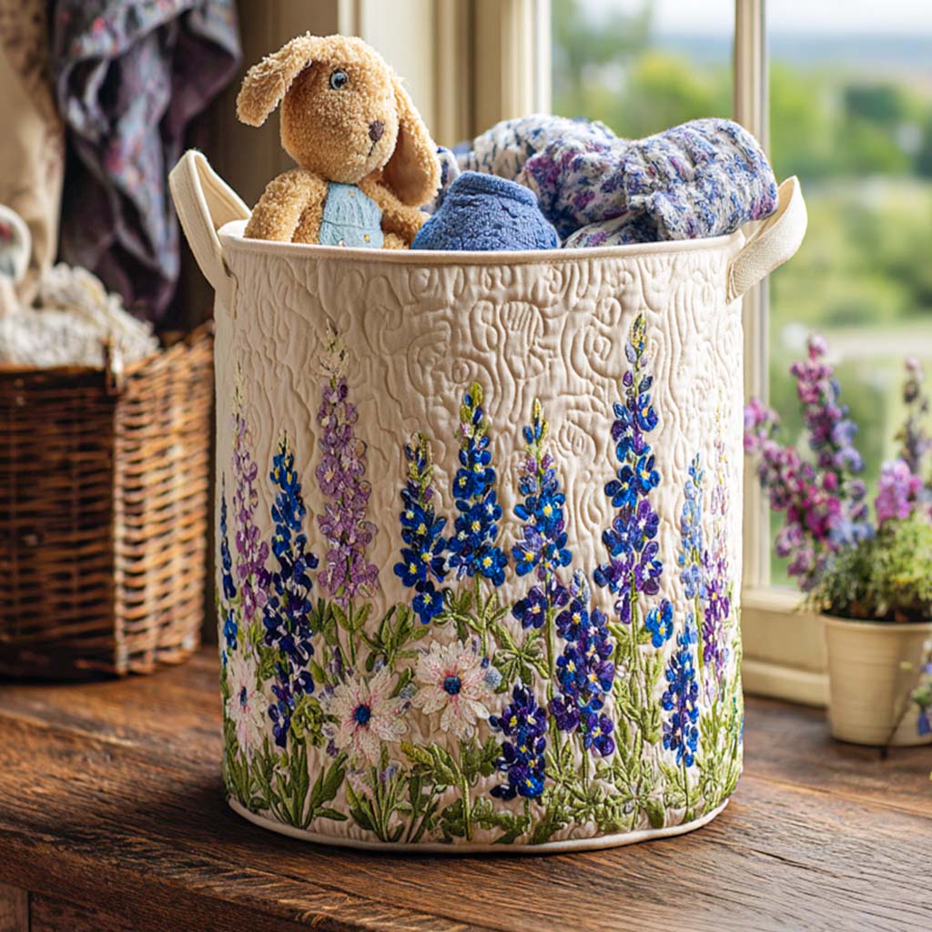 Gräddvit quiltad korg med broderade blå och lila blommor står på en fönsterbräda, fylld med gosedjur och textilier. 1