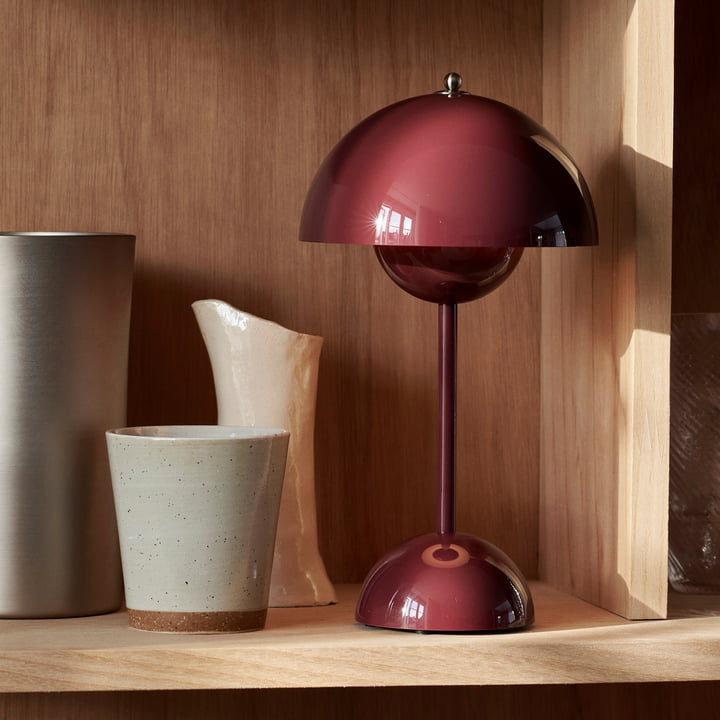 Weinrote Tischlampe aus Metall auf Holzregal, modernes Design, skandinavischer Stil.
