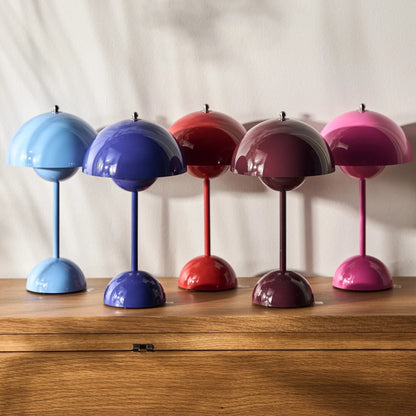 Fünf bunte Tischlampen auf Holzoberfläche, Retro-Design, verschiedene Farben, moderne Beleuchtung.