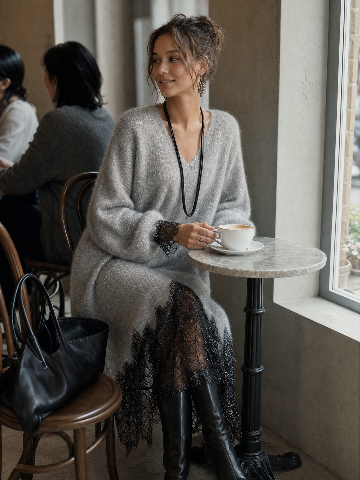 Modell i grå klänning sitter vid ett marmorbord på ett café med en kaffekopp 4