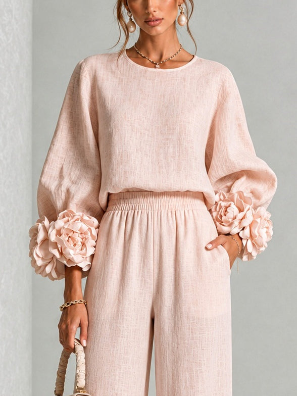 Närbild på rosa överdel med ballongärmar och stora blommor vid ärmslutet, modellen sedd från midjan 8