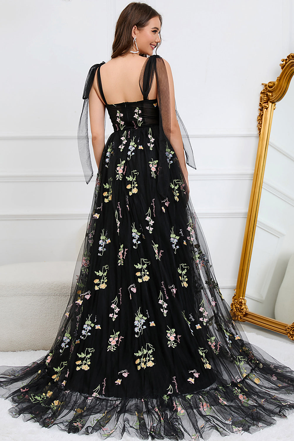 Frau in schwarzem Abendkleid mit Blumenstickerei, elegantes Design, festliche Mode.