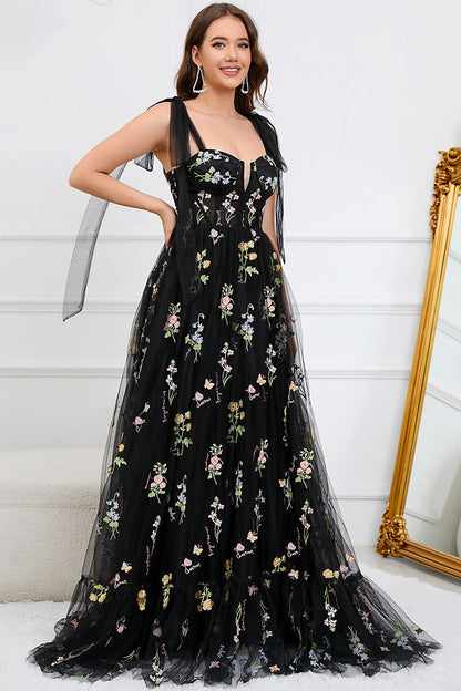 Frau in schwarzem Abendkleid mit Blumenstickerei, elegantes Design, festliche Mode.