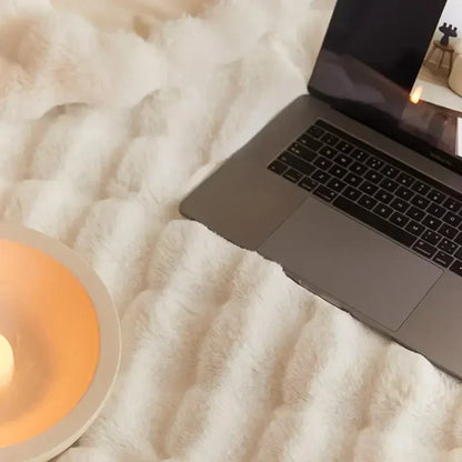 Weiche weiße Decke aus Kaninchenfellimitat mit Laptop, ideal für Sofa oder Büro.