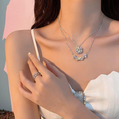 Frau mit silbernem Halsketten-Set und Ring, elegantes Schmuckdesign, weißes Kleid.