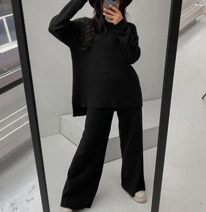 Frau in schwarzem Oversize-Pullover und Hose, Spiegel-Selfie, modisch, minimalistisch, modern.