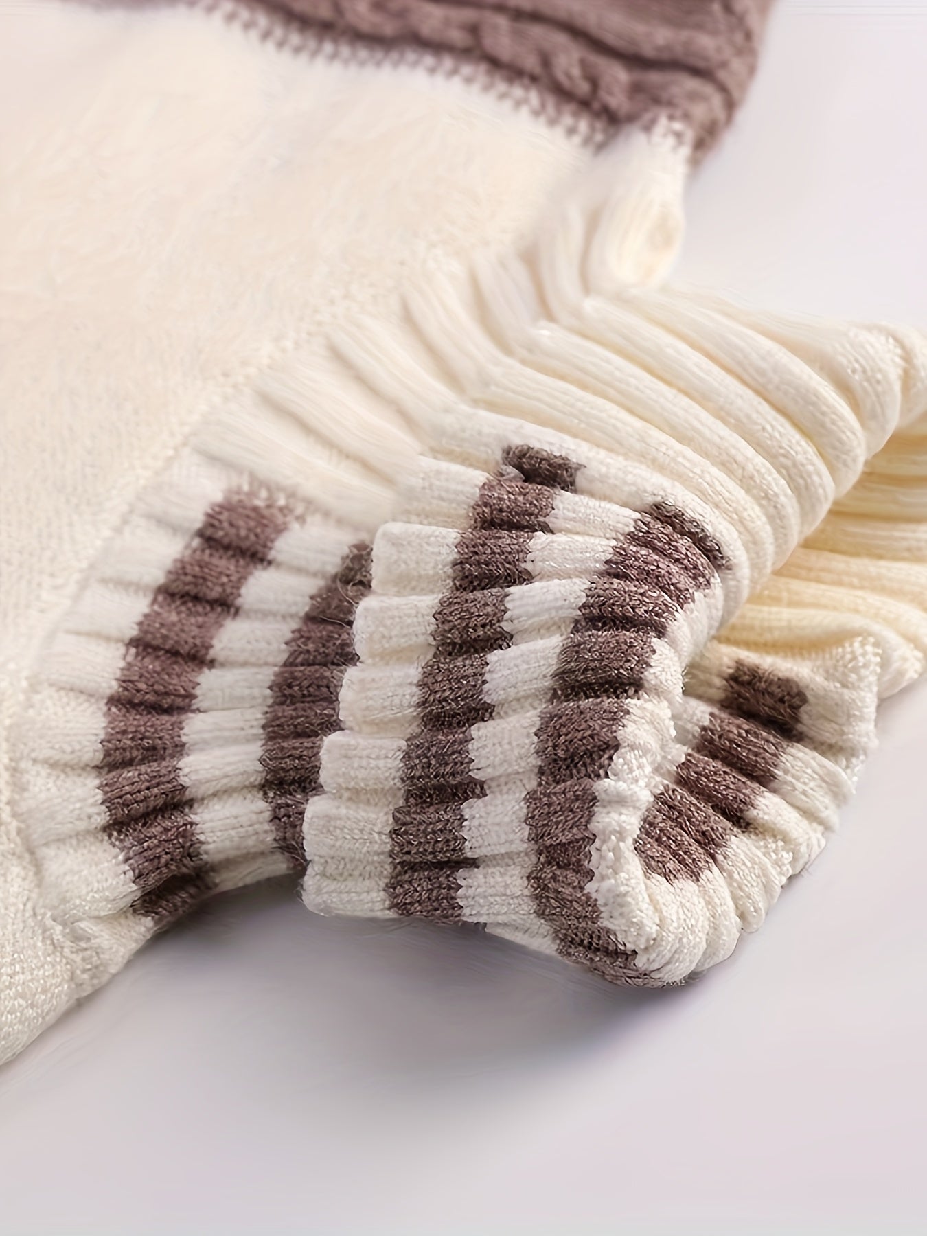 Beige-weißer Strickpullover mit braunen Streifen, weiches Material, modisch, warm.