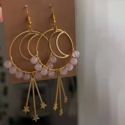 Goldene Ohrringe mit Halbmond-Design, rosa Perlen und Sternanhängern, modischer Schmuck.
