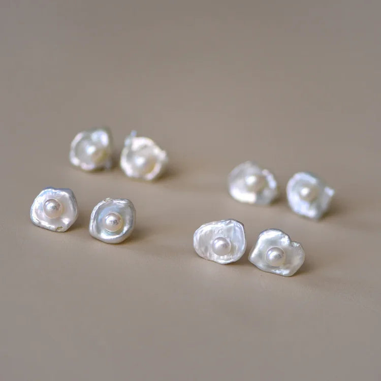 Sechs Paar weiße Perlenohrringe, unregelmäßige Form, eleganter Schmuck, Nahaufnahme.